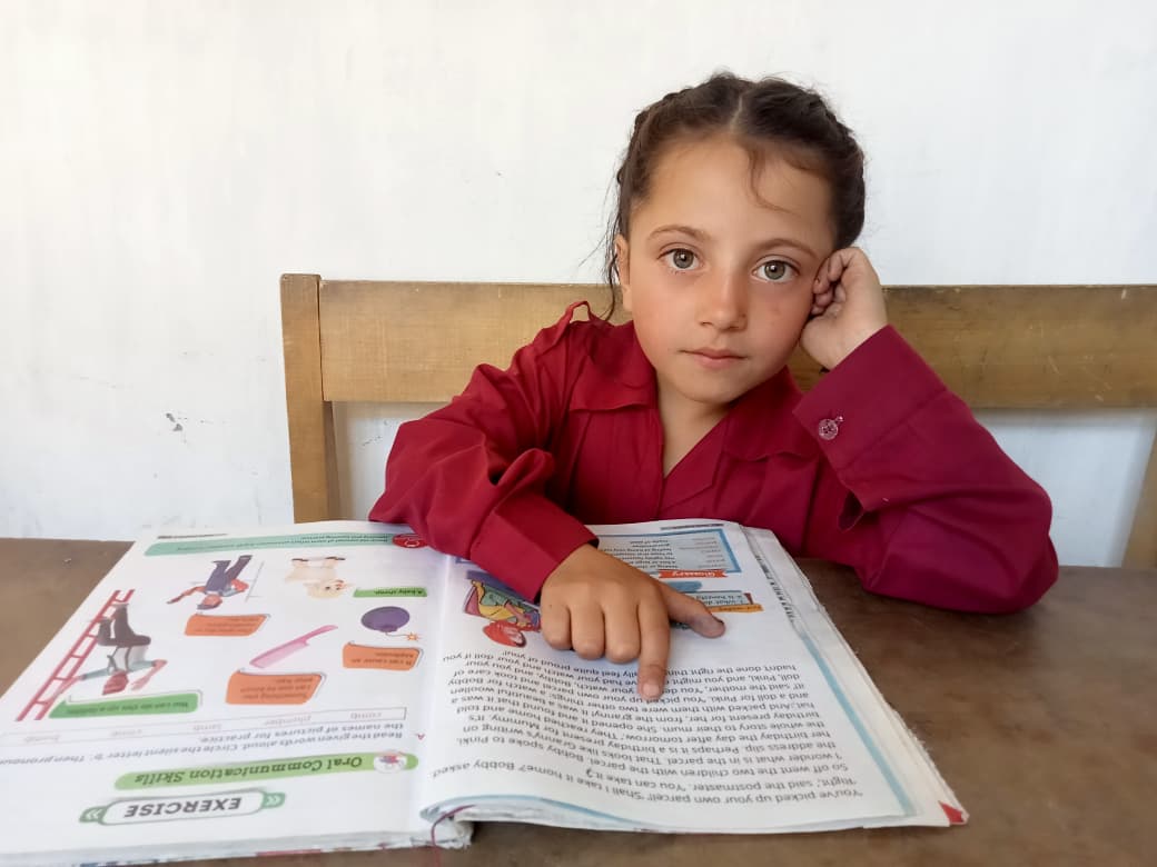 Student reading through an Our Aim Foundation education program